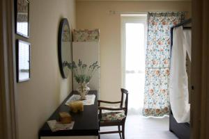 Zimmer mit einem Schreibtisch mit einem Stuhl und einem Fenster in der Unterkunft Casa Vacanze Bellovello in Barbaresco