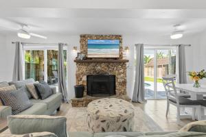 a living room with a couch and a fireplace at Barefoot Bungalow in New Smyrna Beach