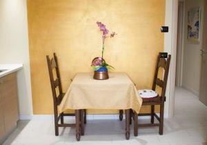a table with a vase with a flower in it at Casa Vacanze Bellovello in Barbaresco