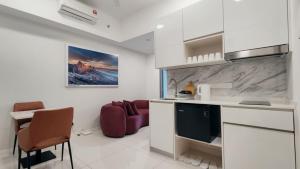 a kitchen with white cabinets and a red couch at Bay Win La,mer Butik in Kota Kinabalu +21 photos