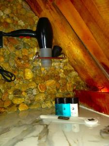 a bathroom with a stone wall with two cups at Shia in Ella +58 photos