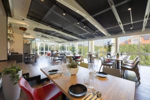 a dining room with tables and chairs and windows at Kremowa Residence by Solarento in Warsaw