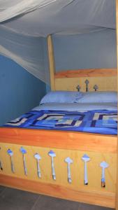 a wooden bed with a blue and white comforter at Perudas Place in Kampala