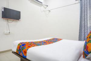 ナーシクにあるHotel Om Saiのベッドルーム1室(カラフルな毛布付きのベッド1台付)