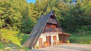 a small house with a black roof with a table at Apartma Jurjovka in Nazarje