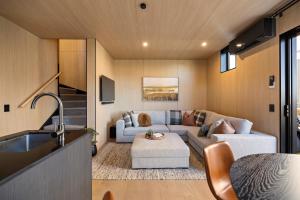 een woonkamer met een bank en een tafel bij Tahuna Luxury Villa Queenstown in Queenstown