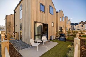 een houten huis met stoelen en een tafel in de tuin bij Tahuna Luxury Villa Queenstown in Queenstown