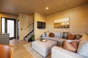 een woonkamer met een bank en een tafel bij Tahuna Luxury Villa Queenstown in Queenstown
