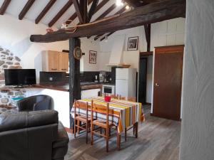 a kitchen with a table with chairs and a kitchen with a counter at Errekarteko-borda in Saint-Jean-le-Vieux