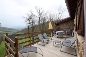 a wooden deck with chairs and a table and a tableearcher at Errekarteko-borda in Saint-Jean-le-Vieux +20 photos