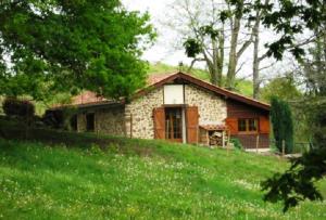 a stone house on a hill in a field at Errekarteko-borda in Saint-Jean-le-Vieux