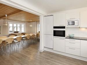 a kitchen with white cabinets and a table with chairs at Seaside Escape in Ho - By Traum Ferienwohnungen in Ho