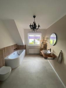 a bathroom with a tub and a toilet and a sink at Brockenblick in Blumenberg +18 photos