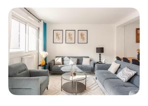 a living room with two couches and a table at Grande Maison XXL in Villiers-le-Bel