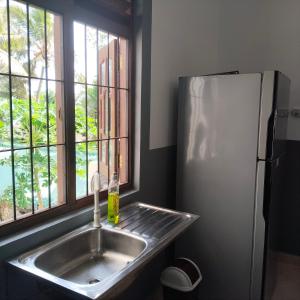 a kitchen with a sink and a refrigerator at Tharul Home in Bentota +37 photos