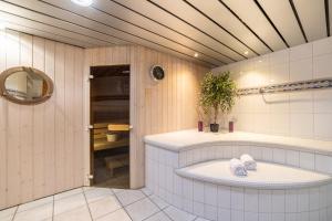 a bathroom with a tub and a sink at Turmhotel Victoria Davos in Davos