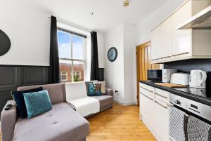 a living room with a couch and a kitchen at 30 percent off! Simple 2 Bed in Central Dewsbury -Sleep 4 in Dewsbury +13 photos