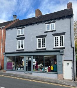 a large white building with a store window at 3 bed flat 10 mins to Alton Towers Sleeps 6-8 people in Cheadle