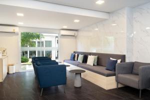 a lobby with couches and chairs in a building at Diya Hotel Bangkok in Amphoe Phra Khanong