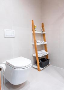 a bathroom with a white toilet and a wooden shelf at Apartment Bergblick in Ebene Reichenau