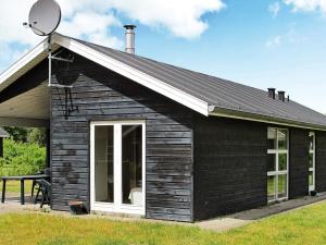 a small black house with a satellite at 6 person holiday home in Hals-By Traum in Hals