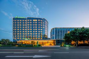 a large building with lights on in front of a street at Holiday Inn Fuzhou Exhibition Center in Fuzhou