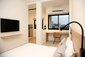 a room with a bed and a television and a desk at Innoplaza Cocody in Abidjan