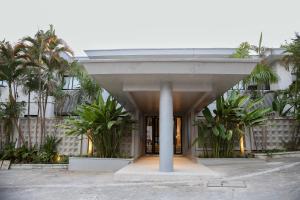 a building with palm trees in front of it at Innoplaza Cocody in Abidjan