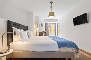 a bedroom with a large bed and a tv at Monte Belvedere Hotel by Shiadu in Lisbon