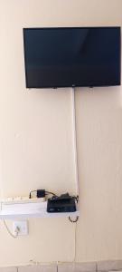 un téléviseur à écran plat accroché au mur dans l'établissement Onyx Luxury cottage, à Randburg