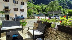 a patio with chairs and potted plants and a building at Casa Adamossi Lombardini in Alpe di Bondeno