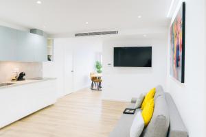 a living room with a couch and a kitchen at Apartamentos TriBeCa Centro V in Albacete