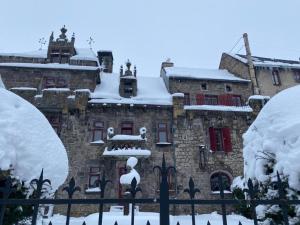 an old stone building covered in snow at Le Manoir des Remparts de Besse in Besse-et-Saint-Anastaise