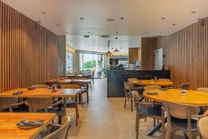 a dining room with wooden tables and chairs at Vila Baleira Residence in Funchal