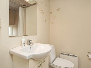 a bathroom with a sink and a toilet and a mirror at 4 person holiday home in Ærøskøbing-By Traum in Ærøskøbing