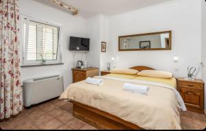 a bedroom with two beds and a mirror and a tub at Villa Ana Apartman s kuhinjom i pogledom na more in Selce +3 photos