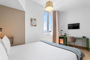 a hotel room with a bed and a desk and a window at Monte Belvedere Hotel by Shiadu in Lisbon