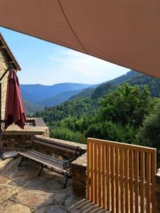 un banco sentado en un patio con vistas a las montañas en Écolieu La Bernarde - Gîte Graphique, en Dompnac