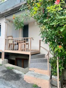 ボルジョミにあるJujuna Guest Houseの建物内の2脚の椅子と階段のあるバルコニー