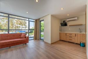 a living room with a red couch and a kitchen at Bun'ca Rooms in Antalya