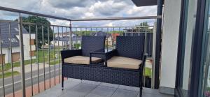a balcony with two chairs sitting on top of a building at Apartament Słoneczny in Kostrzyn nad Odrą