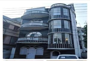 a black building with balconies on the side of it at New Hotel White Palace in kolkata