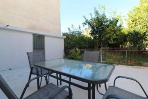 a glass table and chairs on a patio at Katie's House in Sparti