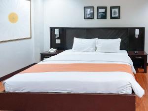 a bedroom with a large bed with two night stands at RedDoorz Plus at Hotel Esse in Davao City