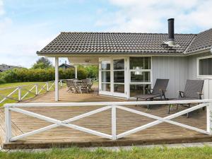 a deck with chairs and tables on a house at 8 person holiday home in Lemvig-By Traum in Lemvig