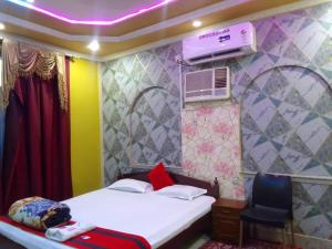 a small bedroom with a bed and a chair at New Hotel White Palace in kolkata +1 photo