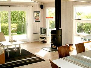 a living room with a stove and a table and a tv at 6 person holiday home in Dronningmølle-By Traum in Hornbæk