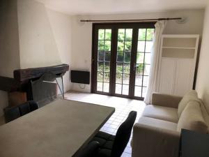 a living room with a couch and a table and a fireplace at 2 pièces avec jardin bord de seine proche forêt Fontainebleau in Samois-sur-Seine +2 photos