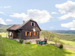 a wooden house on a hill with a picnic table at Chalet in Kalchberg near Klippitztörl Ski in Bad Sankt Leonhard im Lavanttal