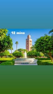 a picture of a tower in a park with a fountain at Appartement Marrakech à 5 min de l'Aéroport in Hbl Hmid +12 photos